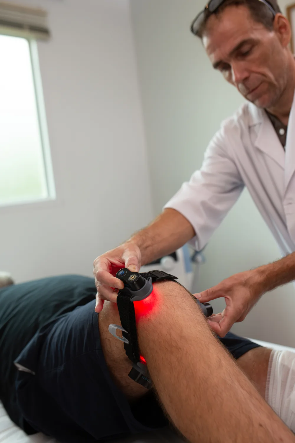 Clinician applying the wearable Kineon MOVE+ device to a client's knee