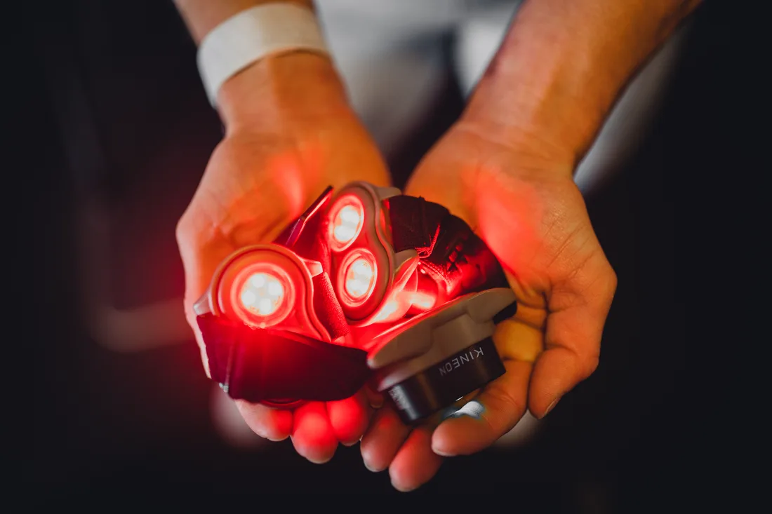 Kineon MOVE+ red light therapy device glowing in use